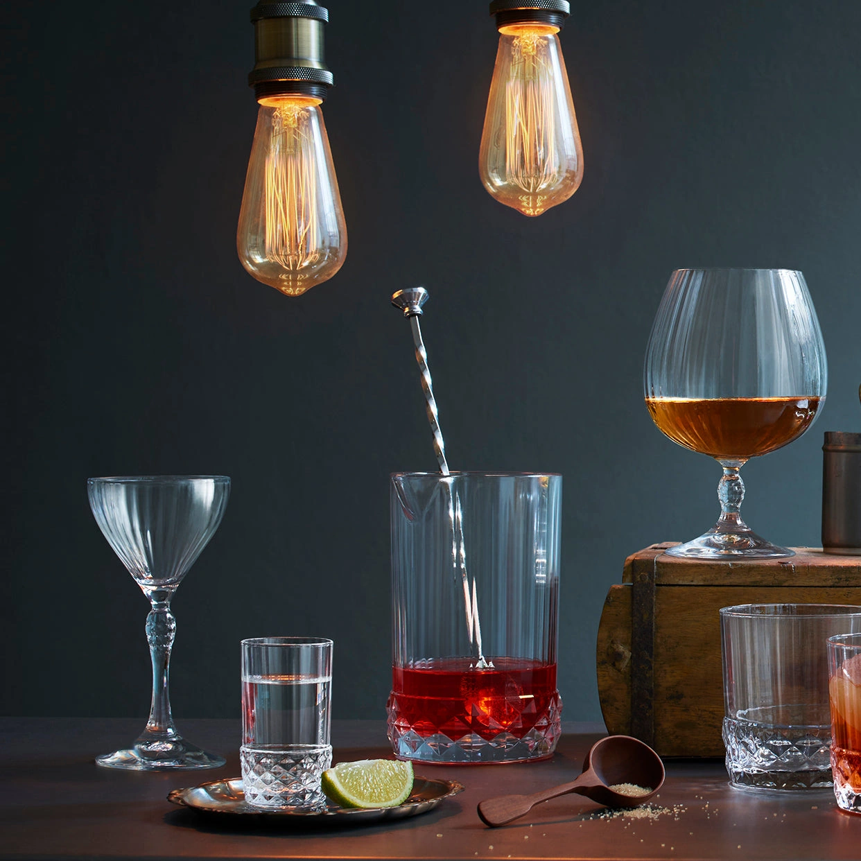 verre à mélange America : le verre à mélange et la cuillère sur un comptoir en bois, parmi les verres de la gamme America '20s