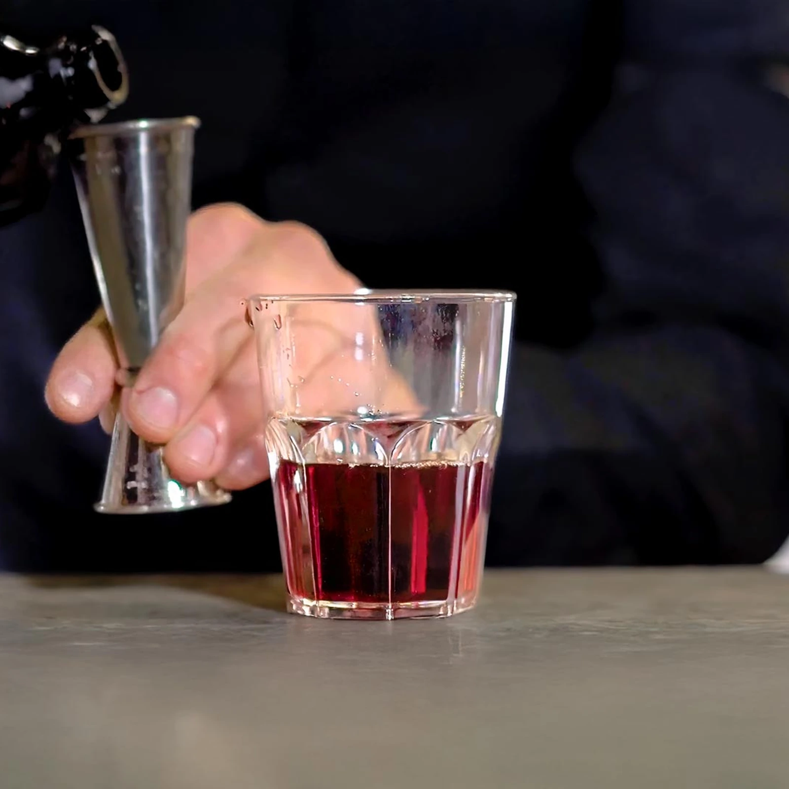 verre incassable Granity Clear 29 cl sur le comptoir, le barman dose un cocktail rouge au jigger